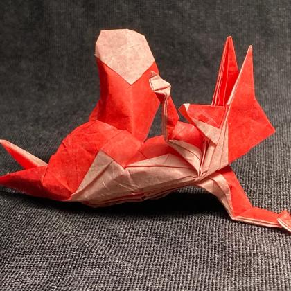 A vulpine-looking humanoid character lying down on one side with right arm raised